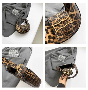 Detail of leopard print saddle bag with golden wavy metal buckle and adjustable strap