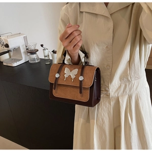 Close-up of retro brown contrast bag with silver metal butterfly clasp in a cafe setting