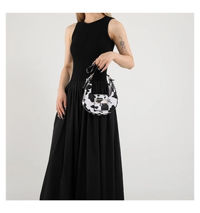 Detail of a chic cow print shoulder bag with a gold buckle on high-quality faux leather