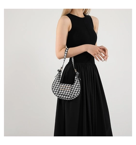 Detail of classic houndstooth hobo bag with sleek crescent shape and metal buckle closure