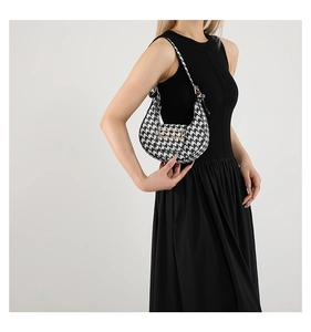 Detail of classic houndstooth hobo bag with gold buckle on model shoulder