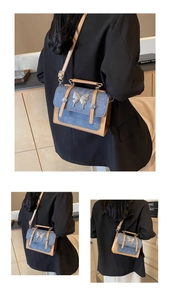 Detail of vintage denim crossbody bag featuring a silver butterfly buckle and rivet accents