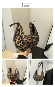 Detailed close-up of leopard print crescent bag with golden hardware and wave accents