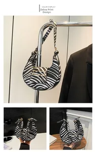 Detail of zebra pattern shoulder bag with golden hardware and adjustable strap
