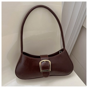 Detail of vintage coffee leather baguette bag with a large gold horseshoe buckle closure