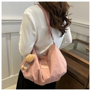 Pink nylon tote bag detail with fashion leather tag and yellow plush chick accessory