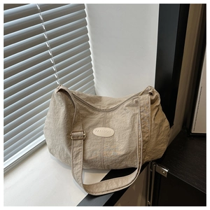 Detailed macro view of nylon shoulder bag texture with fashion patch and metal buckle