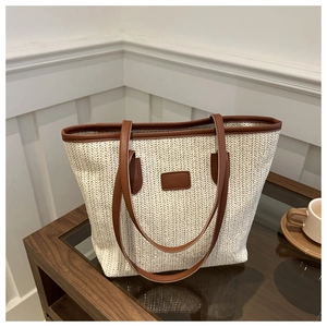 Detail of herringbone straw weave with brown leather trim on a vintage tote bag