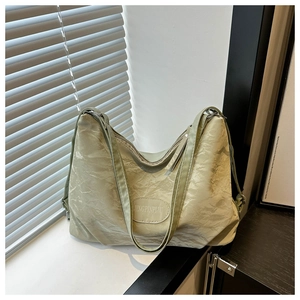 Detail of light green oversized hobo bag with wrinkled texture and brand patch