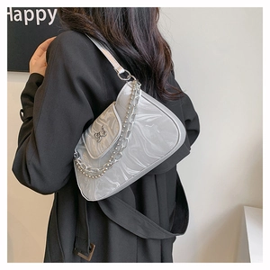 Detail of silver marble moon bag with butterfly buckle and chain on shoulder