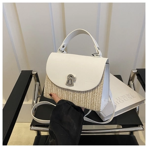 Detail of two-tone straw and white leather crossbody bag with silver buckle