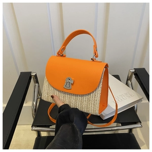 Detail of orange leather and straw woven handbag featuring a silver twist-lock closure