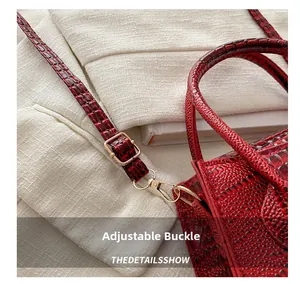 Detail shot of the golden adjustable buckle and red crocodile texture leather strap