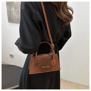 Brown crocodile pattern handbag shown with a shoulder strap for a stylish commute look