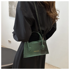 Dark green crocodile pattern handbag with gold lettering shown on model for 2024 style