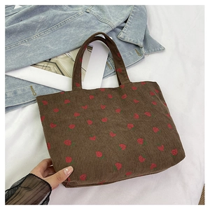 Texture détaillée du sac fourre-tout en velours côtelé marron avec motifs fraises