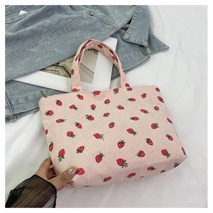 Texture détaillée du cabas en velours côtelé rose avec imprimé fraises et décor denim