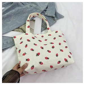 Détail d'un sac cabas en velours côtelé à fraises avec une veste en jean décontractée