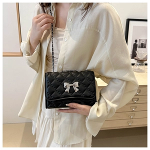 Classic black quilted crossbody bag with silver bow buckle and elegant metal chain strap