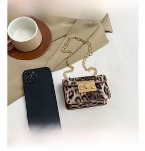 Dettaglio mini borsa leopardata con catena dorata e confronto taglia con smartphone