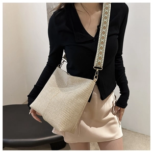 Detail of beige woven tote bag with a geometric pattern wide fabric shoulder strap