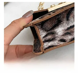 Dettaglio della borsa leopardata con chiusura dorata e cuciture precise sul bordo marrone