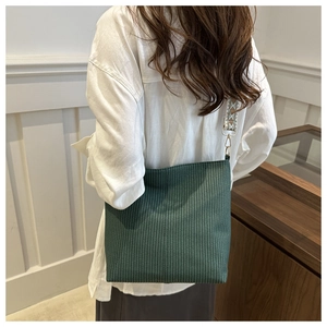 Detail of forest green corduroy tote bag featuring a geometric ethnic style wide strap