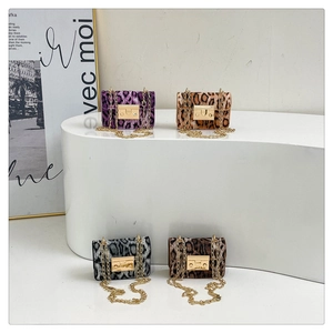 Dettaglio di mini borse leopardate con catena e chiusura dorata in quattro colori