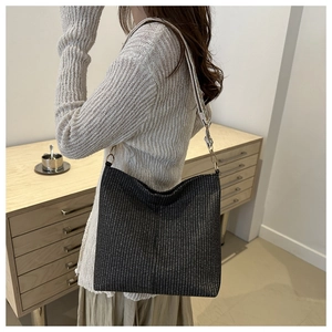 Detail of hobo shoulder bag with black-grey woven texture and ethnic jacquard strap