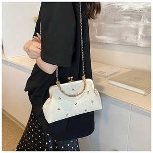 Détail du sac vintage blanc avec clous cœurs dorés et poignée métallique