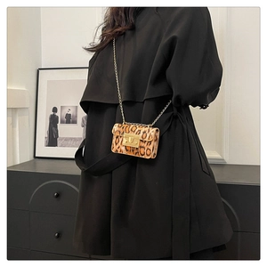 Dettaglio mini borsa leopardata con tracolla a catena dorata e chiusura retrò