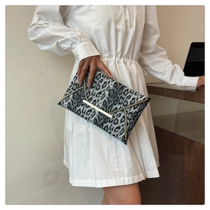 Detail of leopard print envelope clutch with gold V-shaped metal trim and bar