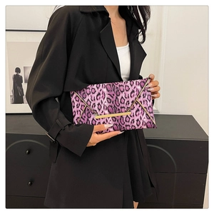 Detail of a purple leopard print envelope clutch with gold V-shaped metal trim