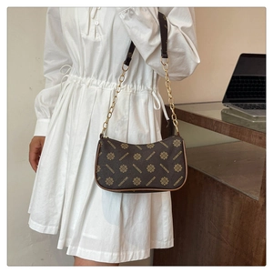 Brown vintage monogram shoulder bag with gold chain strap shown in a lifestyle setting