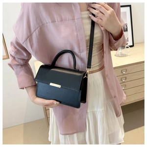 Sac à main chic noir minimaliste en cuir avec détails dorés et bandoulière ajustable
