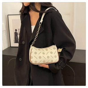 Close-up of beige vintage plaid print baguette bag with gold chain strap detail