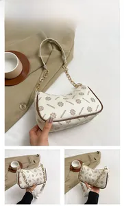 Close-up of white vintage plaid baguette bag with gold chain and leather strap details