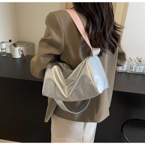Silver cylinder bag with pink strap detail, showing stylish texture and casual fit
