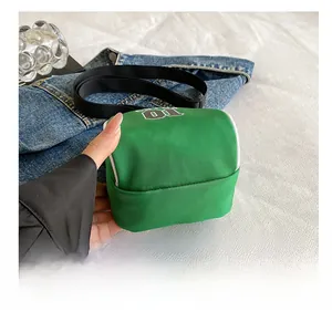 Detail showing the flat wear-resistant bottom of green nylon crossbody bag with 01 logo