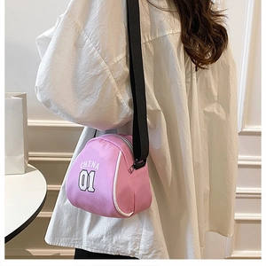 Close-up of pink round canvas bag with China 01 text and adjustable black strap