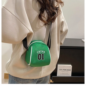Detail view of a green shell-shaped crossbody bag with white China 01 lettering
