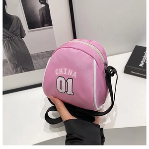 Macro shot of pink composite fabric crossbody bag with China 01 text and white zipper