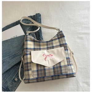 Detail of plaid tote bag with pink bow embroidery and white front pocket flap