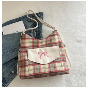 Detail of checkered crossbody bag with pink bow embroidery and white front pocket flap
