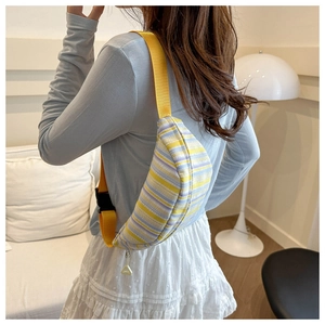 Détail du sac bandoulière rayé coloré avec sangle jaune ajustable sur le mannequin