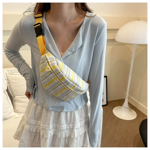 Sac poitrine en toile rayée porté par le mannequin avec bandoulière jaune et boucle rapide