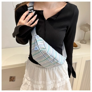 Détail du sac bandoulière en toile à rayures avec sangle réglable et tirette de zip bleue