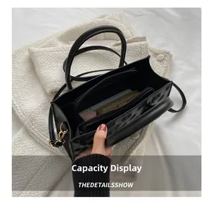 Interior view of black shoulder bag with multi-compartment storage and gold hardware