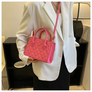 Detail showing hot pink quilted heart pattern on a compact crossbody bag for women