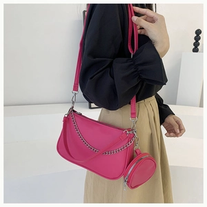 Gros plan sur le sac baguette rose avec chaîne argentée et petite pochette ronde